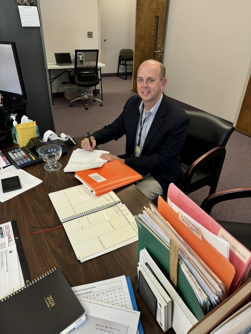 Kevin Berger working at his desk on county paperwork